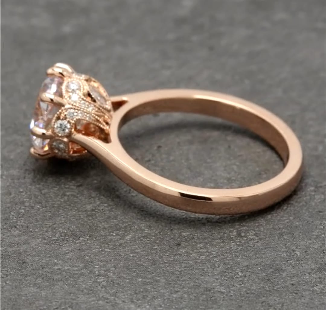 Side profile view showing the intricate milgrain filigree and micro-pavé diamond basket under the center round stone.