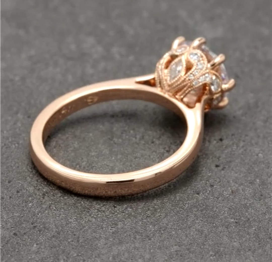 Side view highlighting the smooth polished rose gold band and detailed pavé crown basket setting.