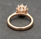 Under-gallery view detailing the micro-pavé leaf-patterned crown setting resting on a rose gold ring band.