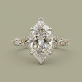 Top-down view of a 4 CT marquise cut lab grown diamond ring with two-tone yellow gold leaf accents and pave diamonds.