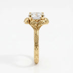 Side profile of a 4 CT round cut lab grown diamond ring in yellow gold featuring an organic bark-textured shank and sculpted leaf prongs.