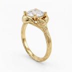 Perspective view of a 4 carat round brilliant lab diamond engagement ring with hand-engraved leaf setting and tree bark yellow gold band.