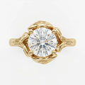 Direct overhead view showing the facet pattern of a 4 CT round brilliant cut lab diamond surrounded by yellow gold leaves.