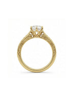 Side profile view of a 3 carat round lab grown diamond ring with 6-prong crown setting and intricate filigree gallery in yellow gold.