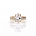 Direct top-down view of a 3 carat marquise cut lab created diamond set on a yellow gold split pavé band.