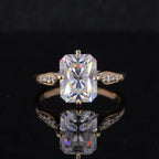 Top face-up view of a 2 CT radiant cut lab diamond ring featuring milgrain-detailed leaf shoulders on a reflective black background.