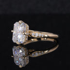 Three-quarter perspective displaying the radiant cut center diamond, tapered accent diamond shoulders, and yellow gold band.