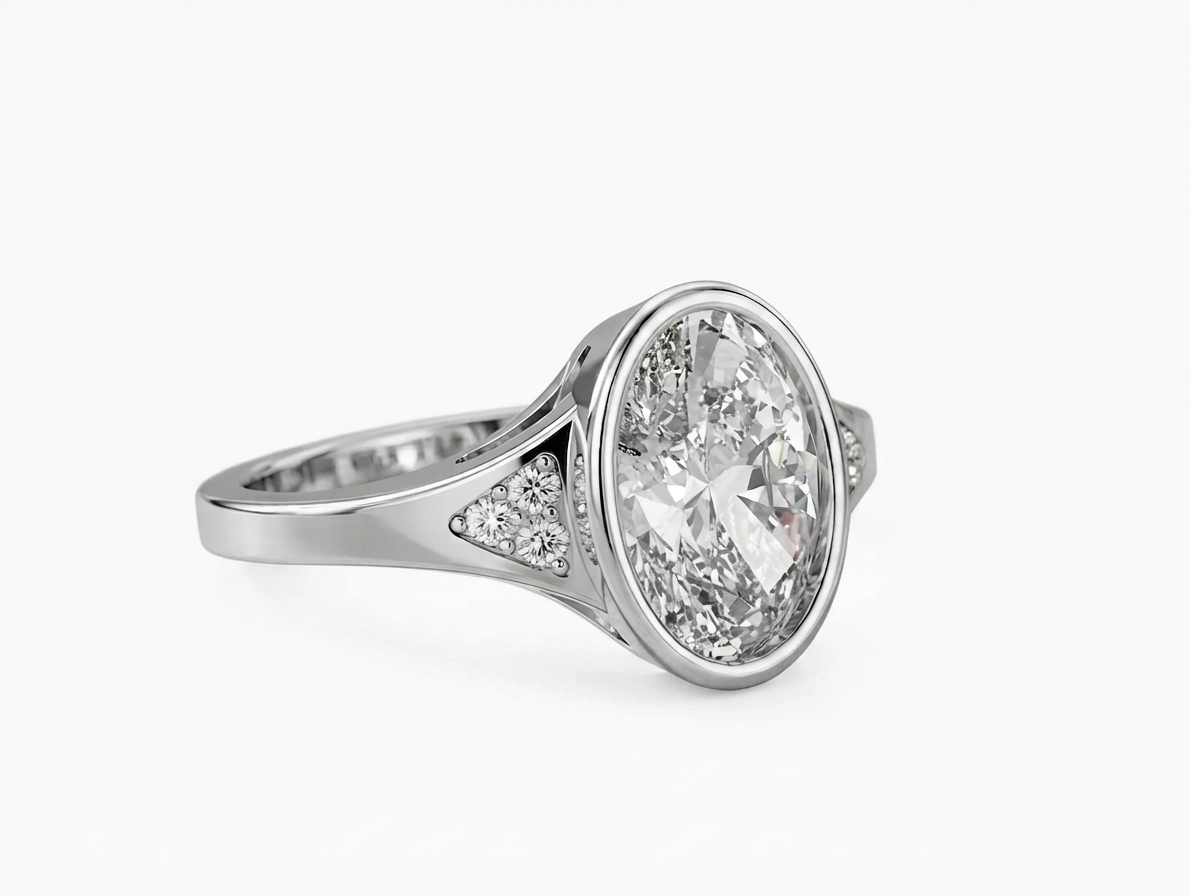Angled view of a 3 CT oval cut lab grown diamond bezel engagement ring in white gold with pave shoulder accents.