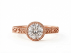 Top-down view of a rose gold 3 carat round cut lab grown diamond solitaire ring with milgrain bezel.