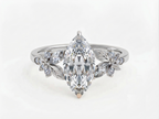 Top view of a white gold 3 CT marquise cut lab grown diamond engagement ring with floral leaf side clusters.