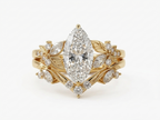 Top-down view of a yellow gold 3 CT marquise lab diamond engagement ring with matching leaf chevron wedding band.