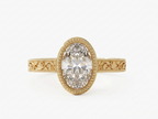 Top view of a 3 CT oval lab diamond ring in yellow gold featuring an engraved filigree band and bezel setting.