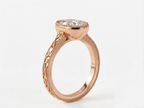 Side profile view of a rose gold 3 CT oval lab grown diamond bezel engagement ring showing band detailing.