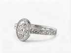 Perspective side view of a white gold 3 carat oval lab grown diamond bezel setting with intricate scrollwork band.