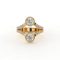 Top view of a two stone round cut lab grown diamond engagement ring with bezel settings in yellow gold.