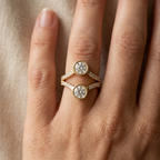 Close-up shot of a two stone round lab diamond Toi et Moi bezel ring worn on hand.