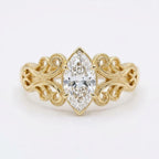 Top-down view of a 4 CT marquise cut lab grown diamond engagement ring with ornate filigree shoulders in yellow gold.