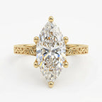Top-down view of a 4 CT marquise cut lab grown diamond solitaire engagement ring with 6 prongs and engraved yellow gold band.