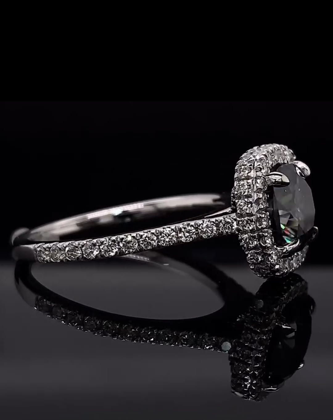 Side profile of a 3 CT grey cushion cut moissanite engagement ring with pave band.