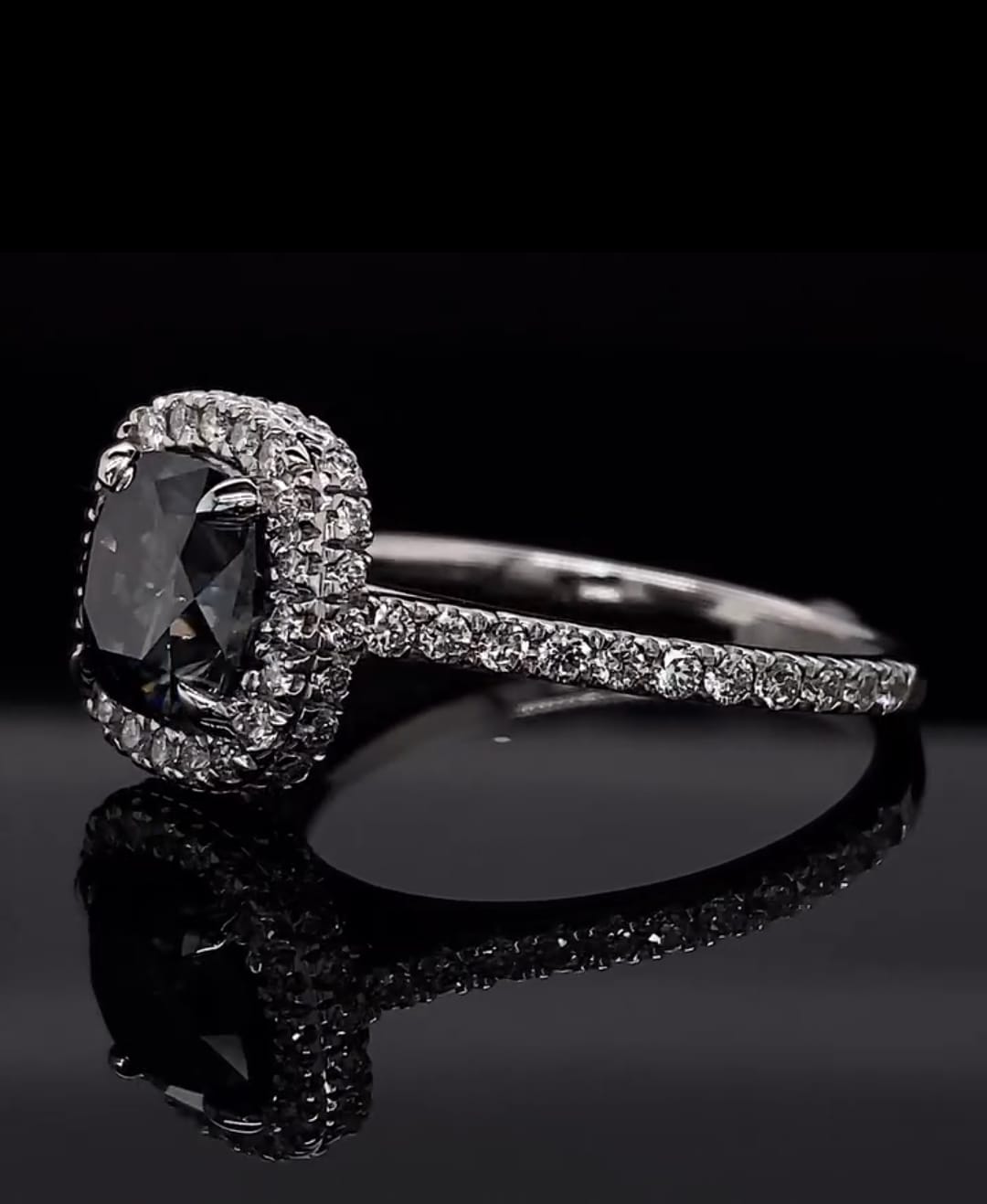 Angled view showing the sparkling double halo of the grey cushion moissanite ring.