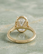 Profile view of a yellow gold 2 CT oval lab diamond ring showing the supportive undergallery basket.