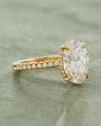 Side profile view displaying hand-engraved scrollwork on the yellow gold band of a 4 CT oval lab diamond ring.   