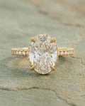 Top-down view of a 4 carat oval lab grown diamond ring featuring pavé set side stones and custom prongs.
