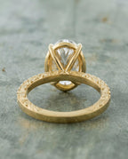 Undergallery profile view showing the structural V-basket and side engraving on a 4 CT oval lab diamond ring.