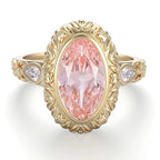 Direct top-down view displaying a 4 CT blush pink oval lab diamond with carved petal halo and pear side stones