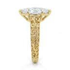 Side profile view showing intricate openwork filigree scrollwork on the yellow gold band of a 3 CT marquise lab diamond ring.