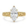 Direct top-down view of a 3 CT marquise cut lab grown diamond ring with vintage leaf filigree band in yellow gold.