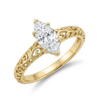 Perspective angled view of a 3 carat marquise cut lab diamond engagement ring with 6-prong setting and carved filigree band.