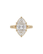 Top-down view of a 4 CT marquise cut lab grown diamond ring with star-set accent diamonds on yellow gold band.