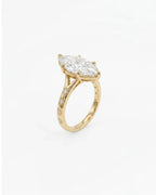 Perspective angled view of a 4 carat marquise lab diamond celestial ring with starburst engraving and 6-prong setting.