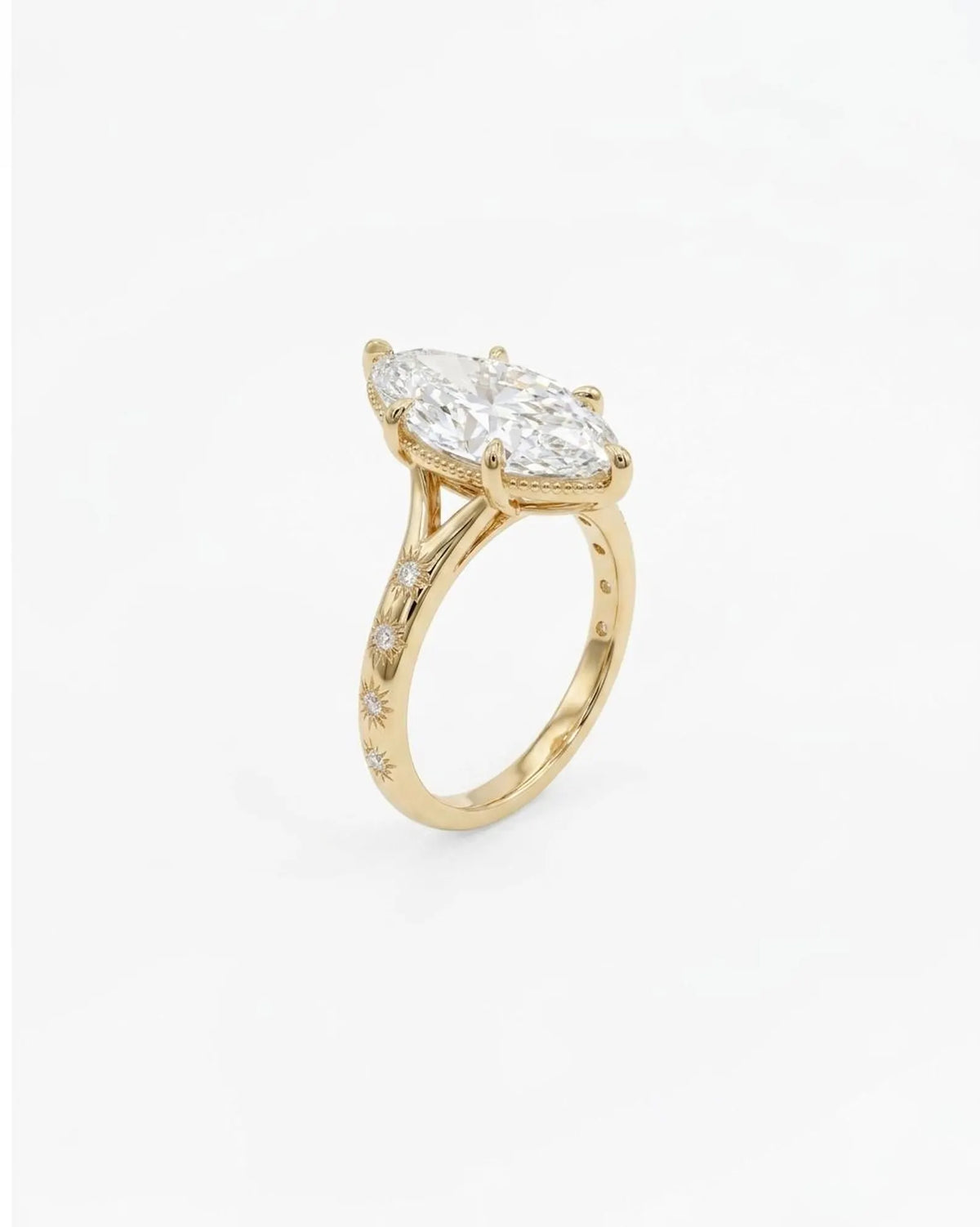 Perspective angled view of a 4 carat marquise lab diamond celestial ring with starburst engraving and 6-prong setting.