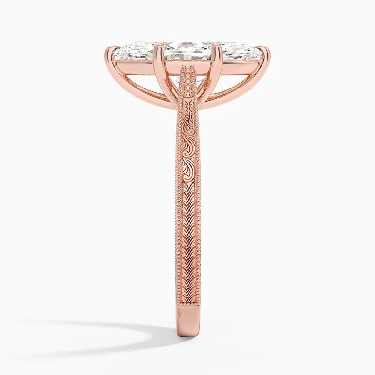 Side profile view of a 3 CT marquise lab diamond engagement ring showing hand-engraved scrollwork on a rose gold band.   