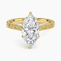 Direct top-down view of a 3 CT marquise cut lab grown diamond solitaire ring on an engraved yellow gold band.