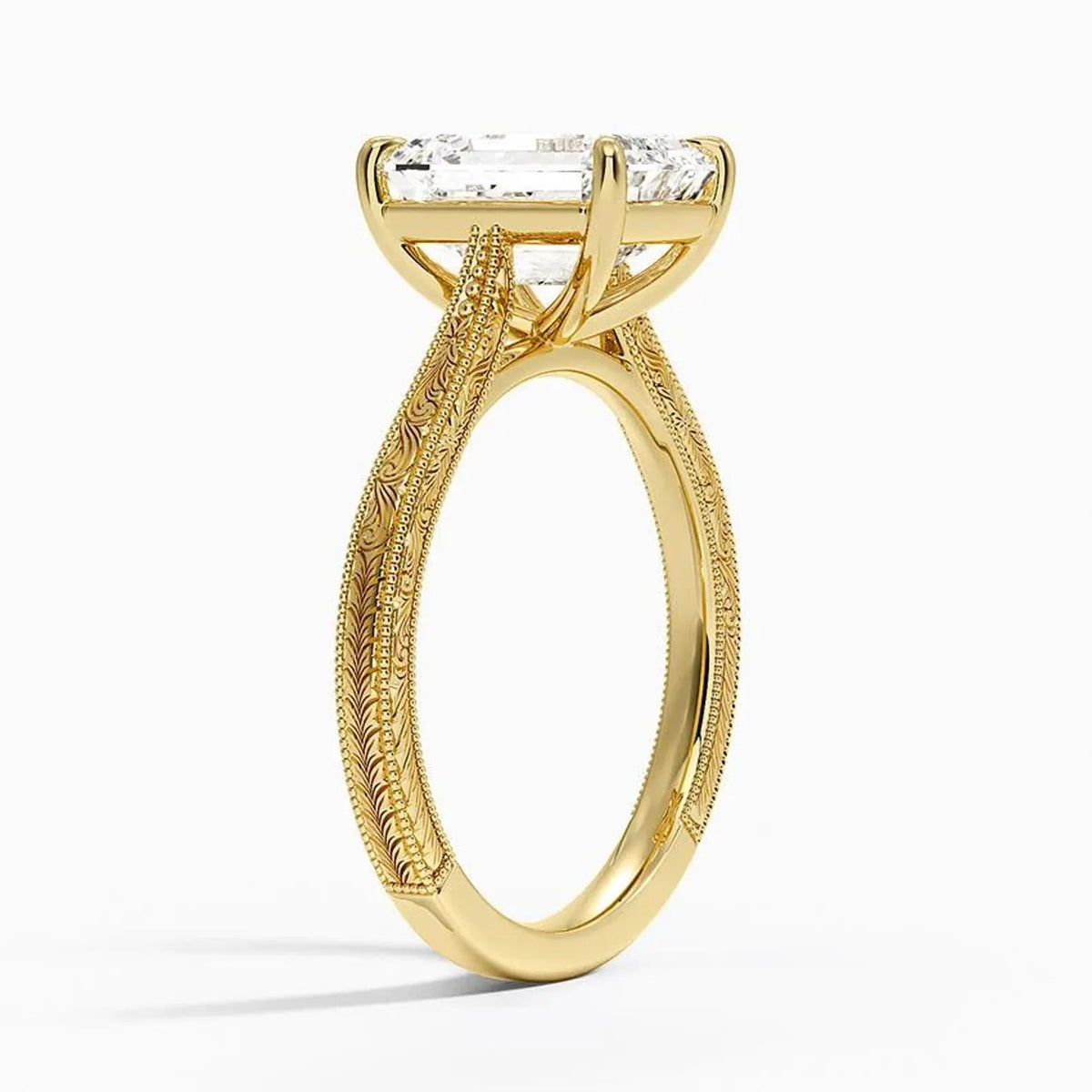Perspective view of a 3 carat emerald cut lab grown diamond ring with carved scrollwork in yellow gold.