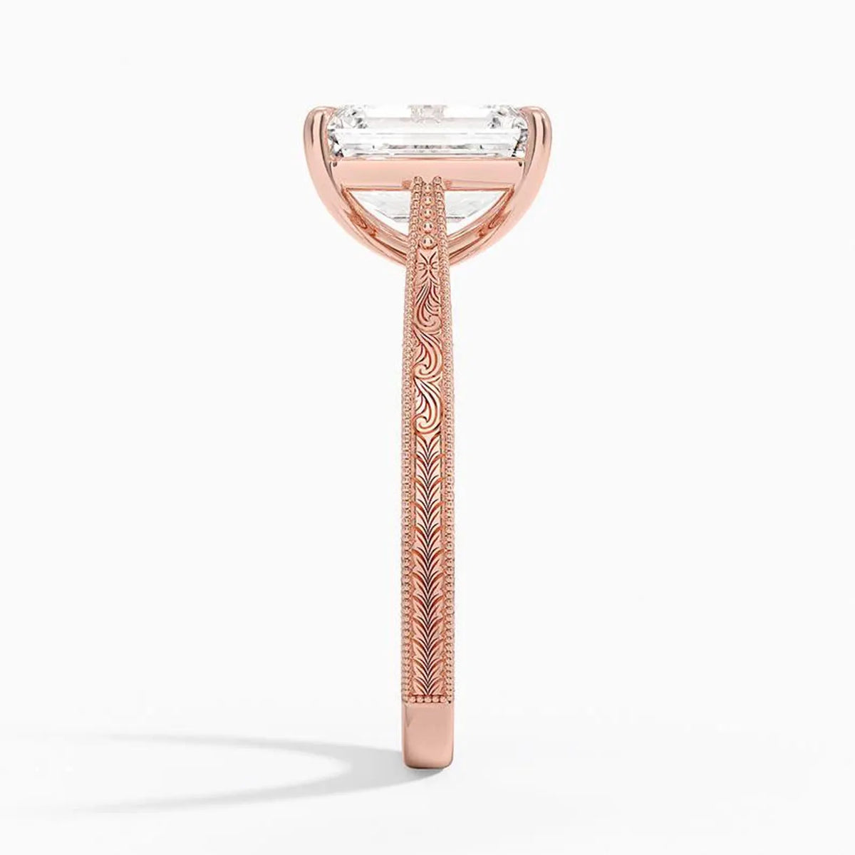 Side profile view showing intricate scrollwork engraving and milgrain detailing on a rose gold band.