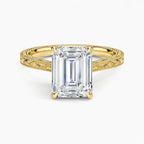 Direct top-down view of a 3 CT emerald cut lab grown diamond engagement ring with vintage carved shoulders in yellow gold.