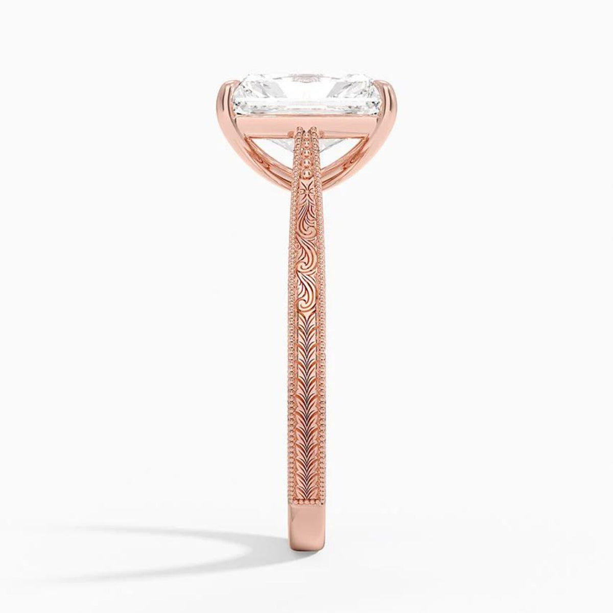 Side profile view of a 3 CT radiant cut lab diamond engagement ring showing hand-engraved scrollwork on a rose gold band.