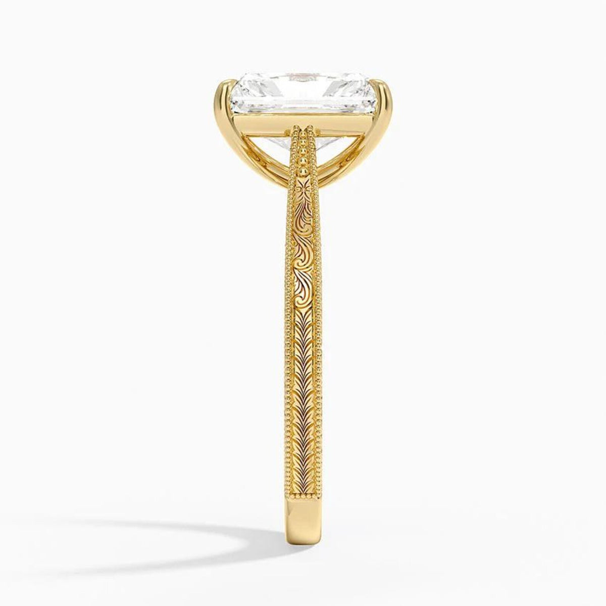 Side profile view showing intricate scrollwork engraving and milgrain detailing on a yellow gold ring band.