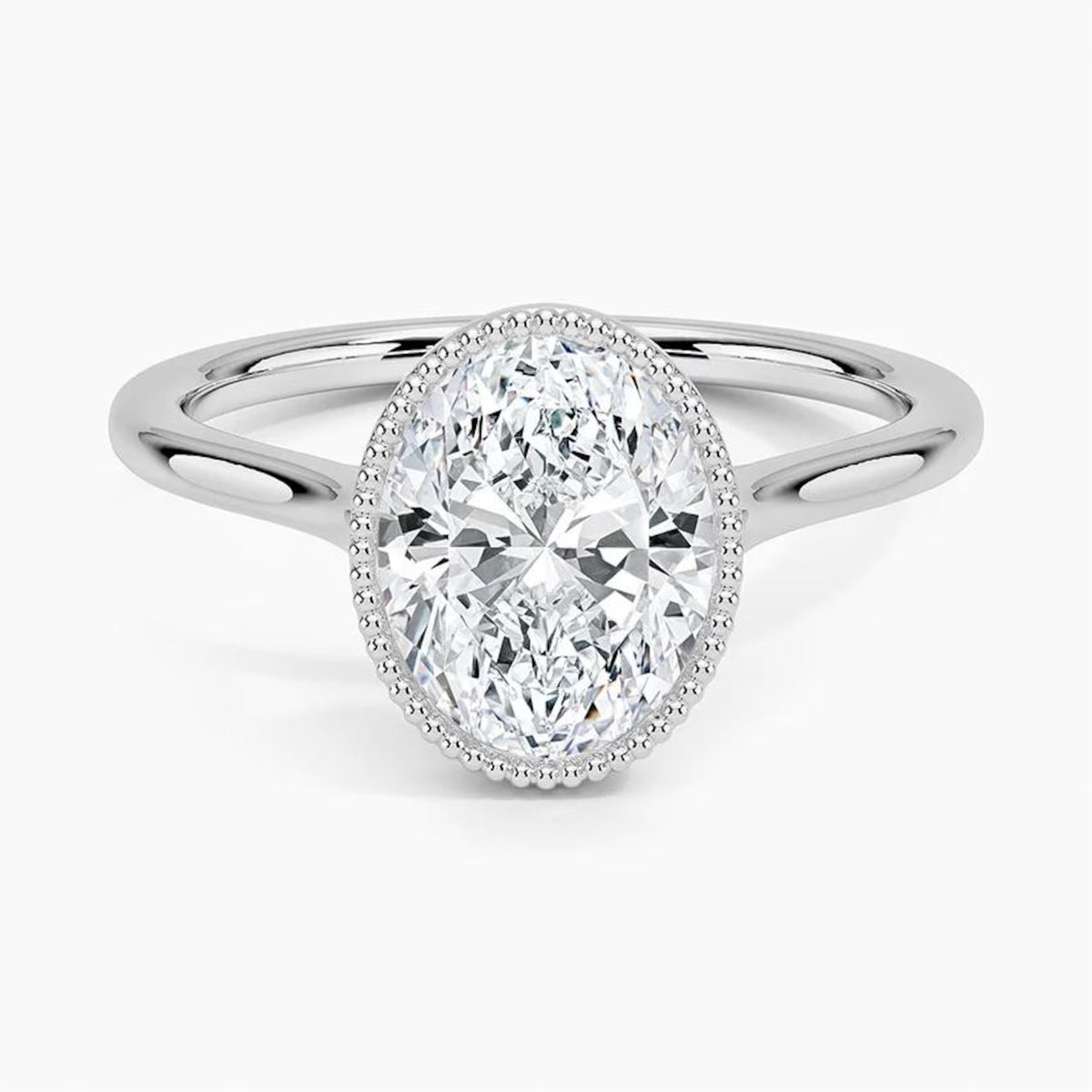 Front perspective view of a 3 CT oval lab diamond engagement ring in a milgrain bezel white gold setting.