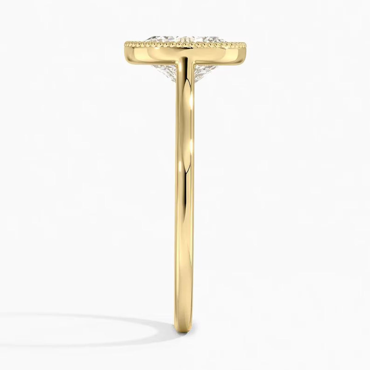 Side view showing yellow gold band and low-profile oval diamond milgrain bezel setting.
