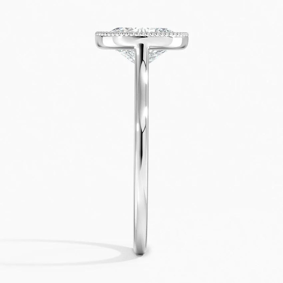 Direct side edge view of a white gold milgrain bezel solitaire ring with a 3 CT oval lab diamond.