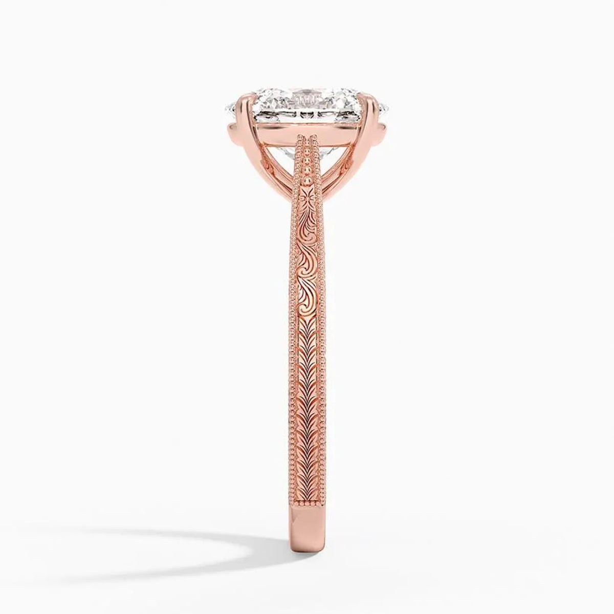Side profile view of a 3 CT oval cut lab diamond engagement ring showing hand-engraved scrollwork on a rose gold band.