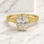Top-down perspective view of a 3 CT oval cut lab diamond engagement ring with engraved shoulders on a marble background.