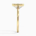 Direct side profile view of a yellow gold engagement ring featuring a 4 CT emerald cut diamond and milgrain rim.