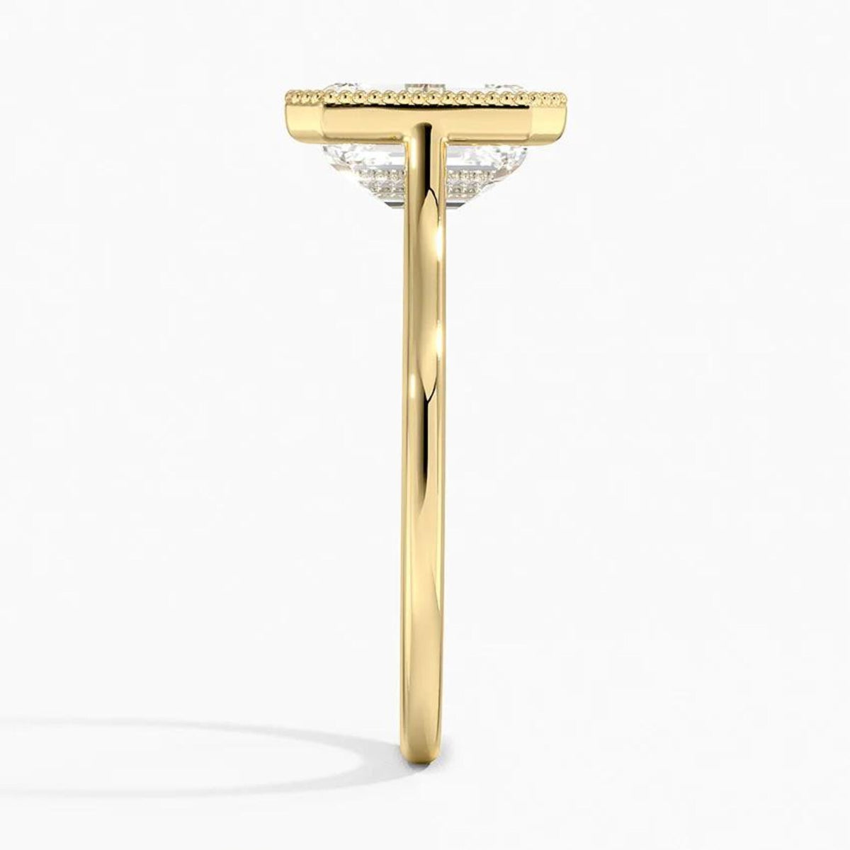 Direct side profile view of a yellow gold engagement ring featuring a 4 CT emerald cut diamond and milgrain rim.