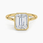 Direct top view of a 4 CT emerald cut lab diamond solitaire ring with a milgrain bezel in yellow gold.